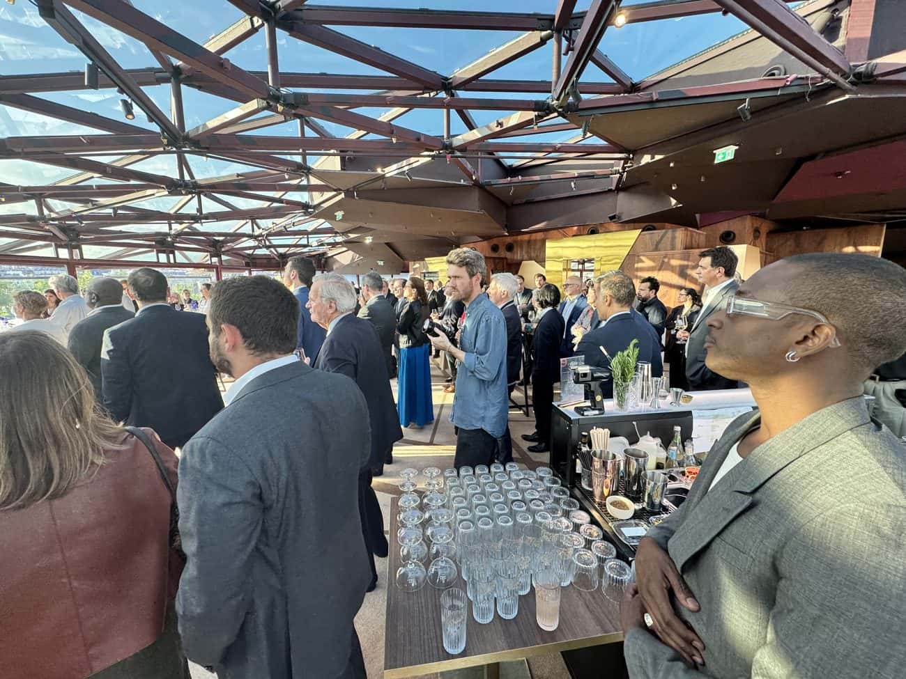 Invités en costume un verre à la main lors d'un événement d'entreprise Mixodyssée