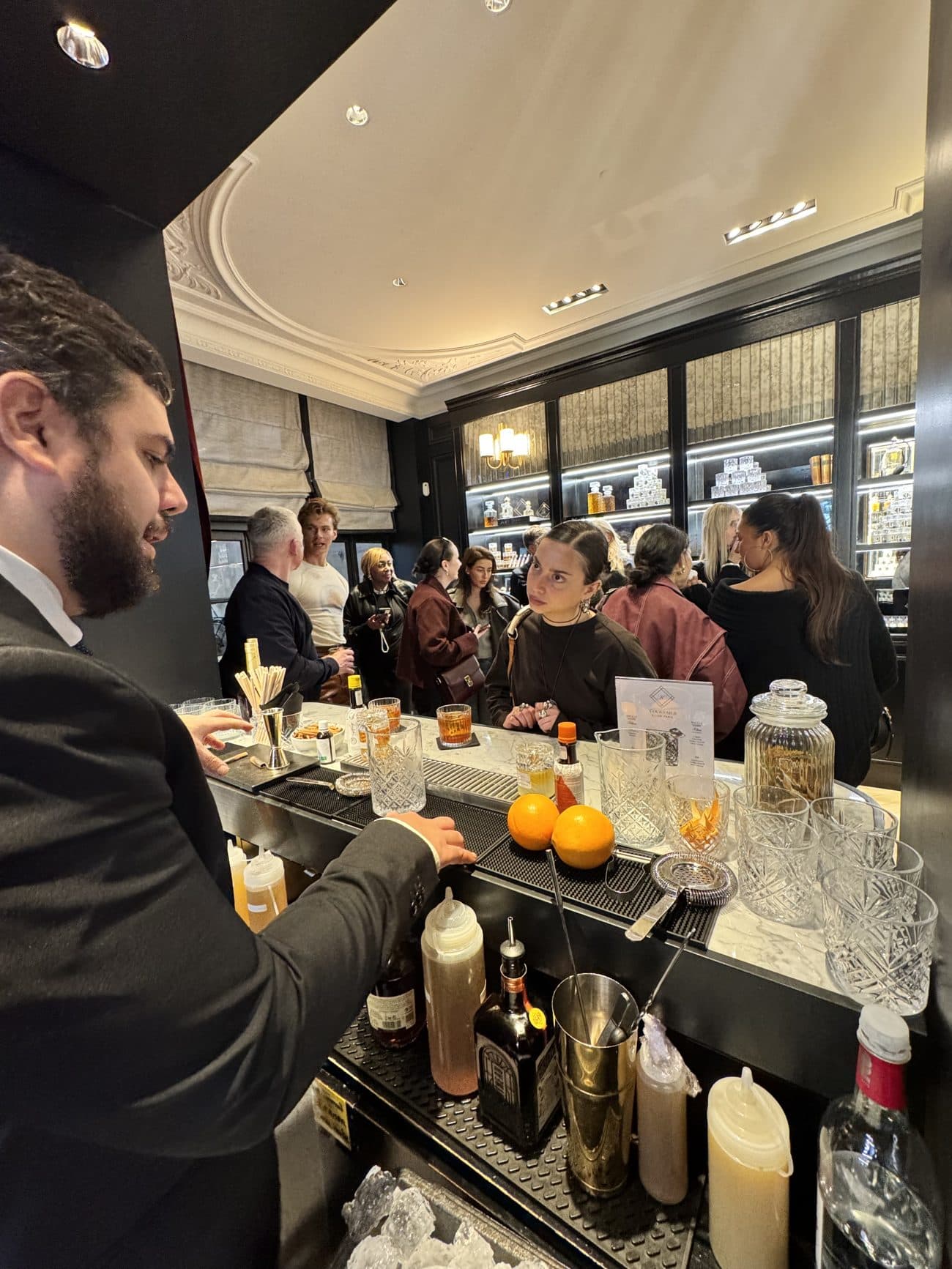 Deux mixologues Mixodyssée en action derrière le bar, en noir et blanc
