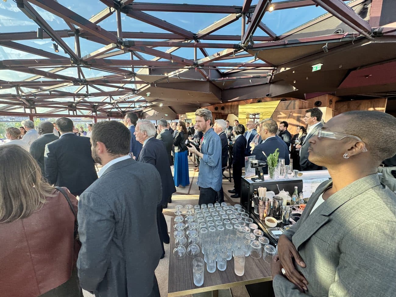 Invités en costume un verre à la main lors d'un événement d'entreprise Mixodyssée
